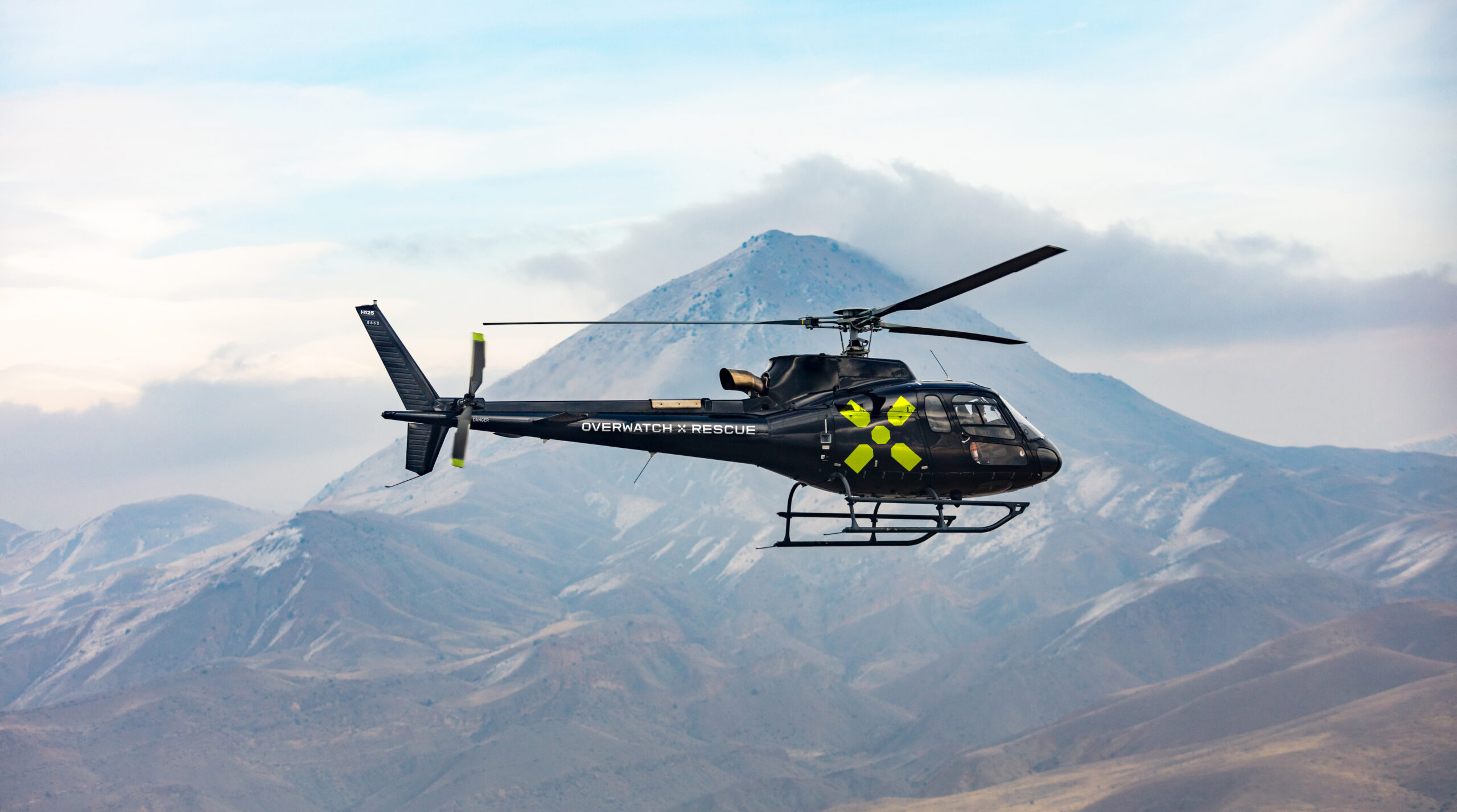 Helicopter,In,Flight.,Black,Helicopter,Is,Flying,Between,Mountains,Peak,